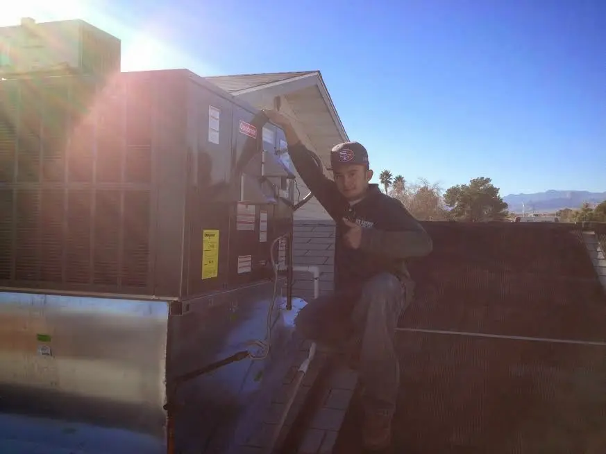 HVAC technician performing AC Tune-Up on a rooftop unit in Clyde